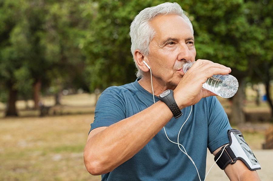 Senior man drinking water and Hyalogic® Hyaluronic Acid after a workout